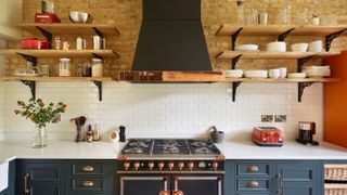 blue kitchen with range cooker and large cooker hood