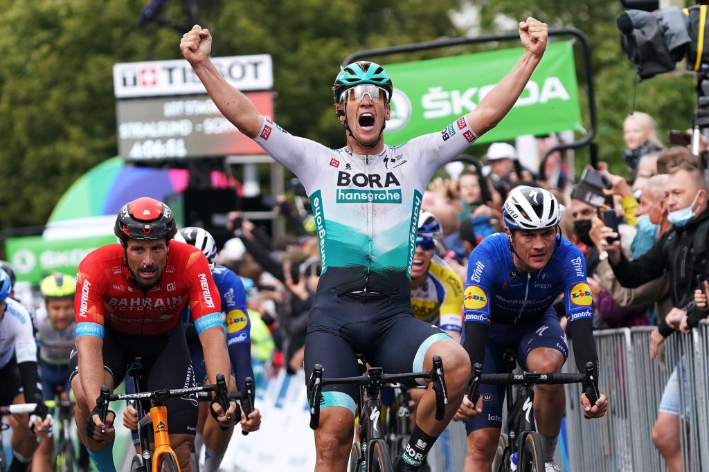 SCHWERIN GERMANY AUGUST 26 Pascal Ackermann of Germany and Team Bora Hansgrohe celebrates at finish line as stage winner ahead of Marco Haller of Austria and Team Bahrain Victorious L and Yves Lampaert of Belgium and Team Deceuninck QuickStep R during the 35th Deutschland Tour 2021 Stage 1 a 191km stage from Stralsund to Schwerin DeineTour on August 26 2021 in Schwerin Germany Photo by Christian KasparBartkeGetty Images