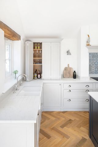 kitchen corner cabinet in white kitchen with wooden floorboards