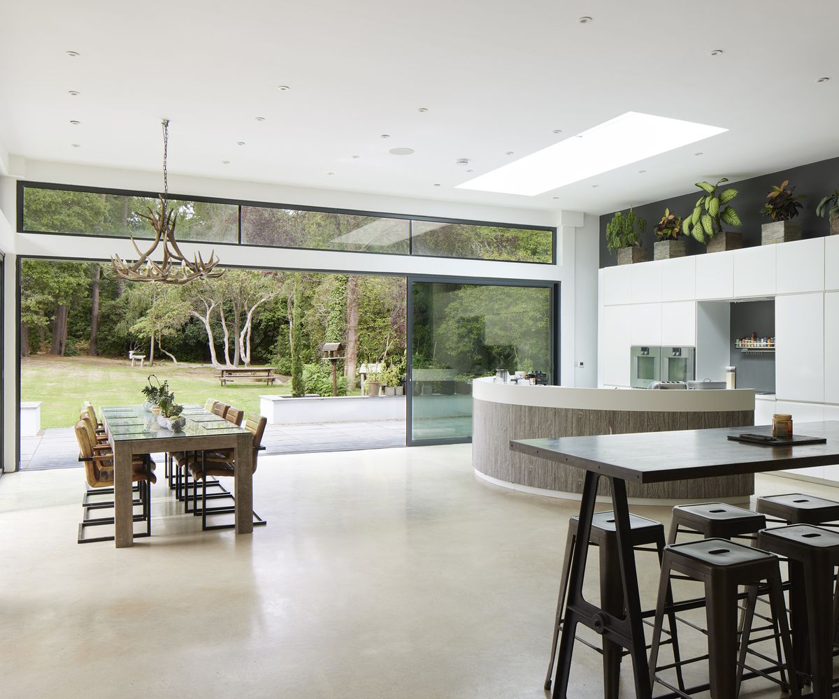 an open plan kitchen and dining room with connecting walls outdoors creating a open feel with the outside
