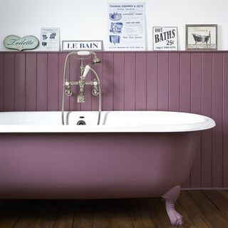 bathroom with wooden flooring bathtub and purple wall