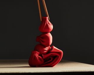 A number of red-shaded dumplings are photographed under dramatic light in a still-life shooting.