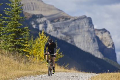 man riding gravel bike in mountainous scenery