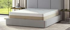 The Saatva Contour5 Mattress on a grey upholstered bed frame in a luxurious bedroom