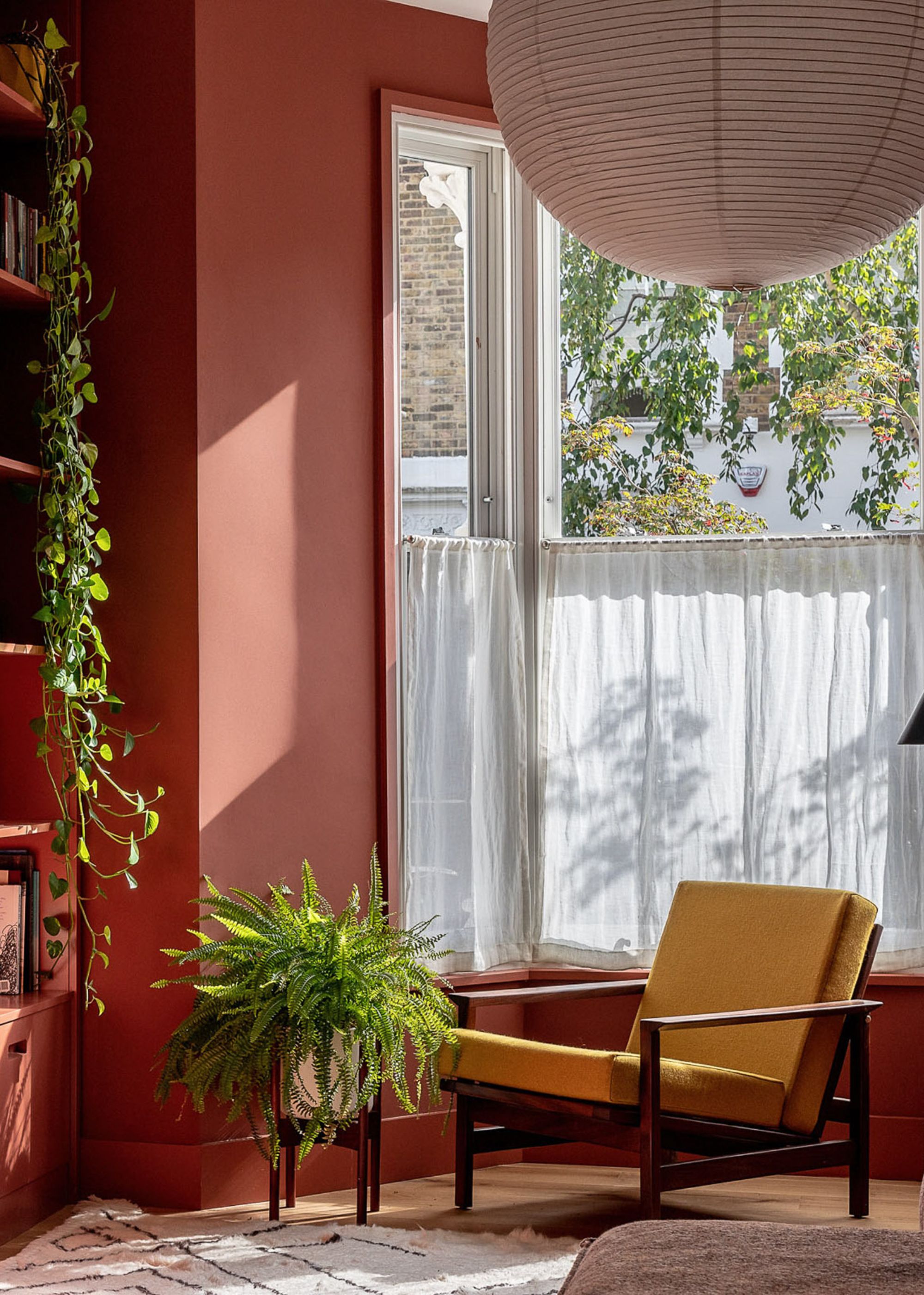 living room with terracotta wall and yellow chair