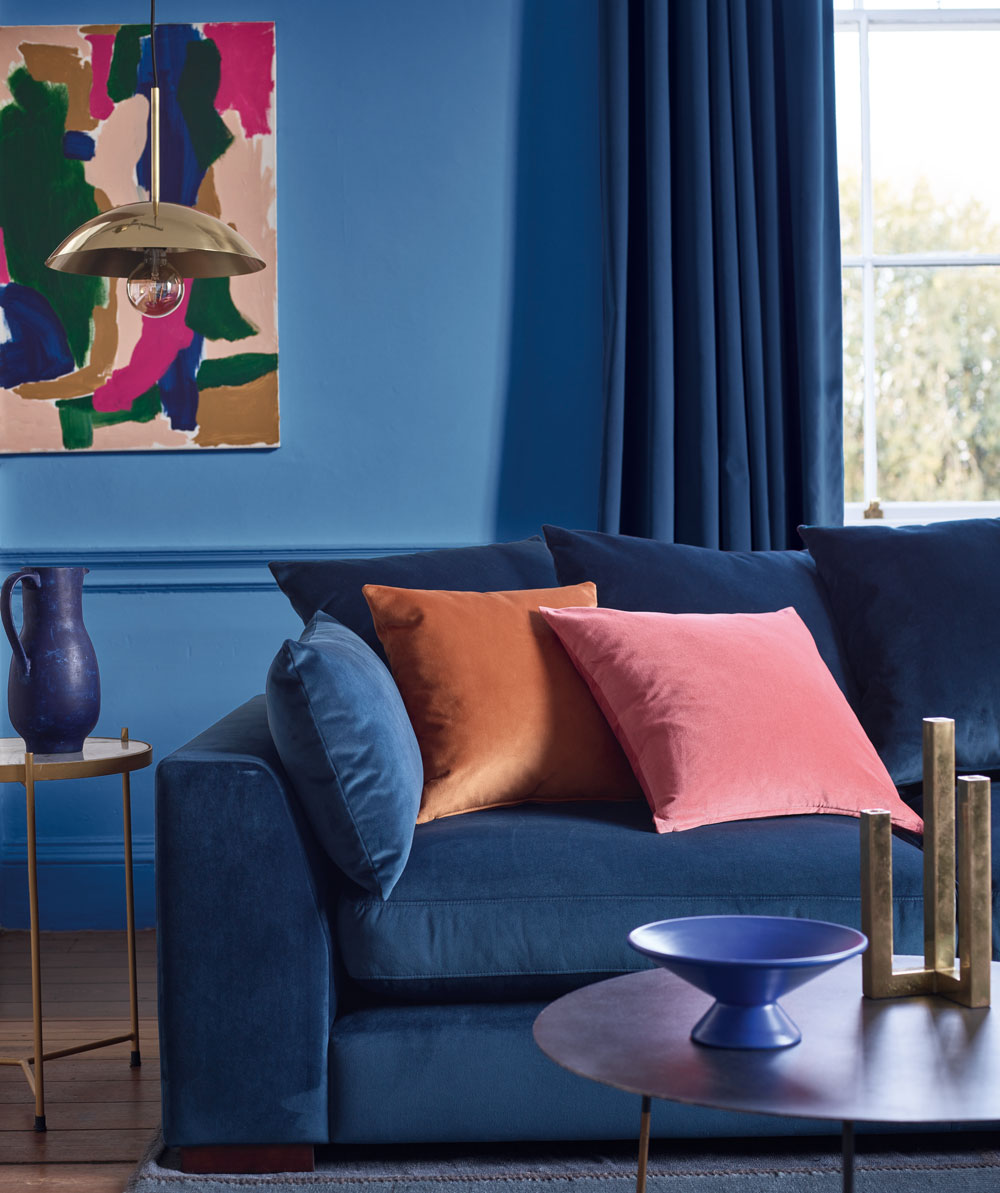 DFS sofa with cushions and a blue wall