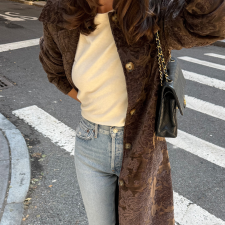 An image of a woman wearing best long winter coat to wear with jeans 2026