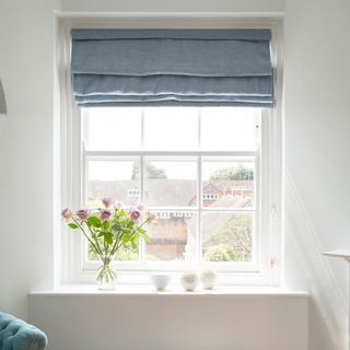 White window with blue roman blind