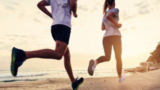 A couple running on the beach at sunset