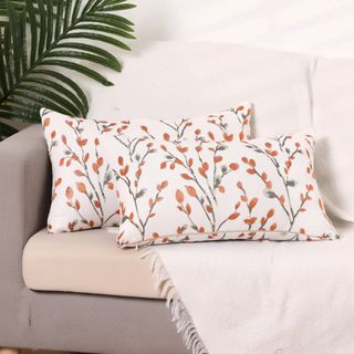 Two patterned throw pillows on a gray sofa