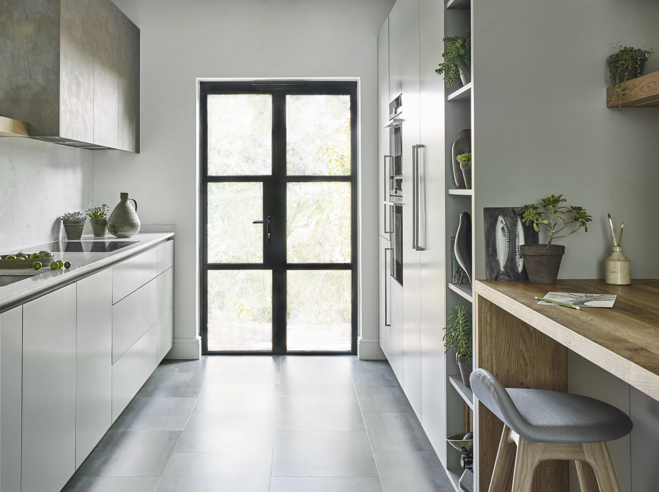A modern white and grey kitchen leading to crittall style back doors