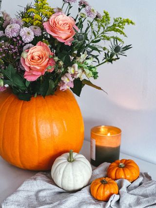 A pumpkin used as a vase for roses