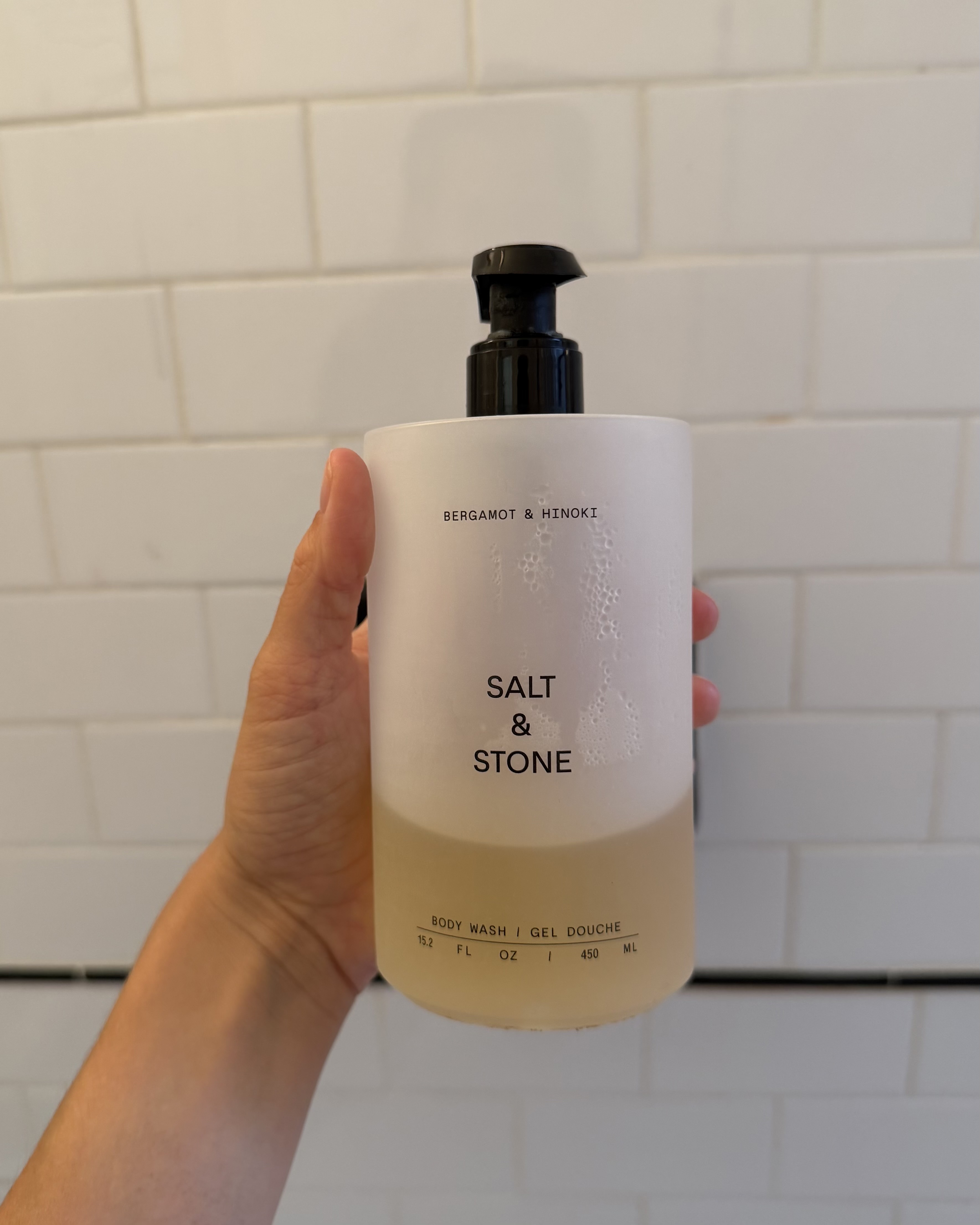 An image of associate beauty editor Alyssa Brascia holding the Salt &amp;amp; Stone Bergamot and Hinoki Body Wash.