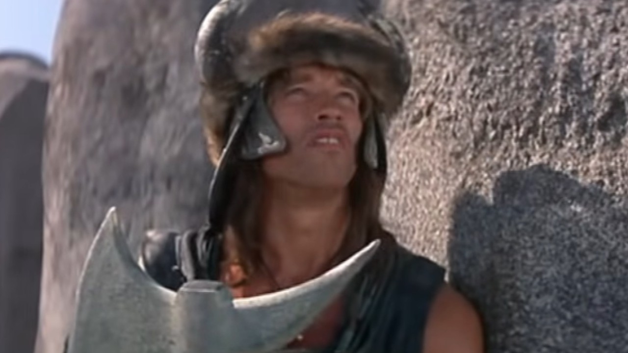 Arnold Schwarzenegger holding an axe in Conan the Barbarian